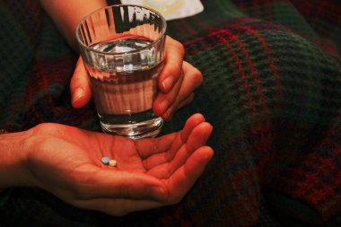 El tıp hapları ve bir bardak su