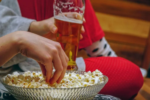 Elinde bira bira ile bir kase mısır ile evde tv izlerken uyuyanlar
