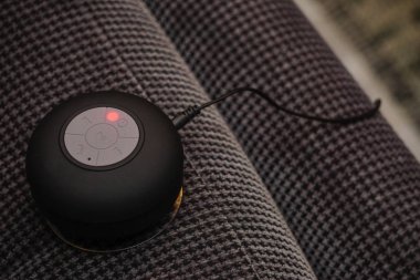 Küçük bluetooth hoparlör kanepede yakın görünümü şarj ediliyor