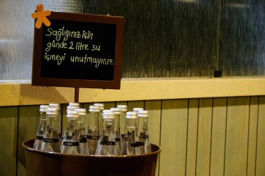 Yukarıda bir uyarı ile sepette Cam su şişeleri