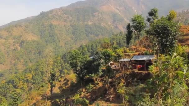 Típico pueblo tradicional de montaña situado en la ladera a lo largo del sendero de trekking en el Himalaya en Nepal — Vídeos de Stock