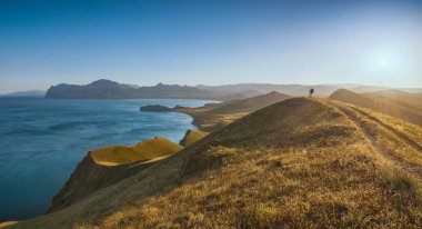 Uzun yürüyüşe çıkan kimse Crimea dağ Vadisi günbatımı karşı tepedeki silüeti. Seyahat ve macera kavramı.