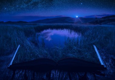 Küçük dağ gölü bir ay ışık açık bir büyülü kitap sayfalarında. Görkemli manzara. Doğa ve eğitim kavramı.