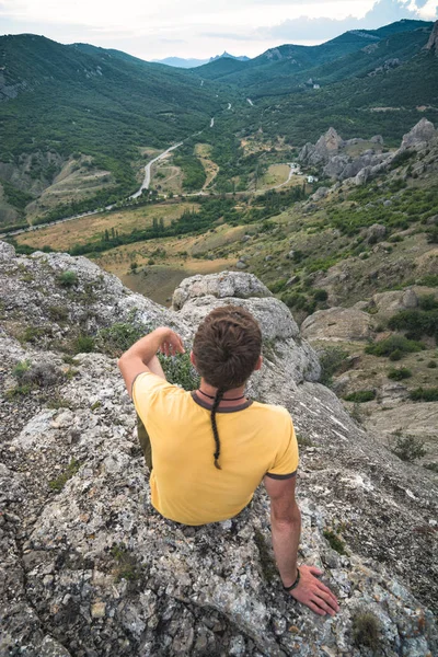 Mladý Muž Sedící Skalnatém Kopci Vychutnat Horské Údolí — Stock fotografie