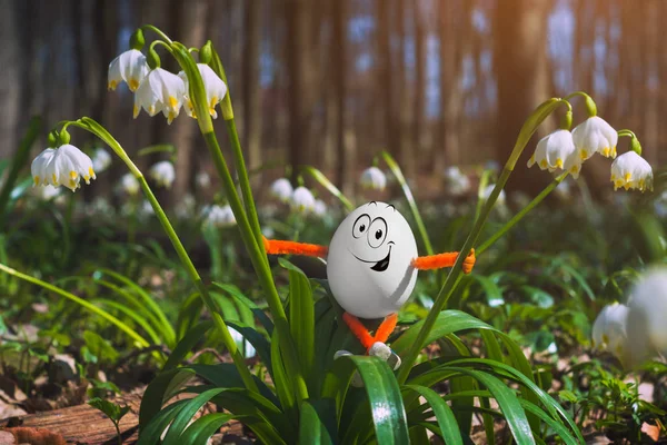 Mutlu Paskalya yumurtası beyaz çiçeklerle bahar orman. Tatil kavramı.