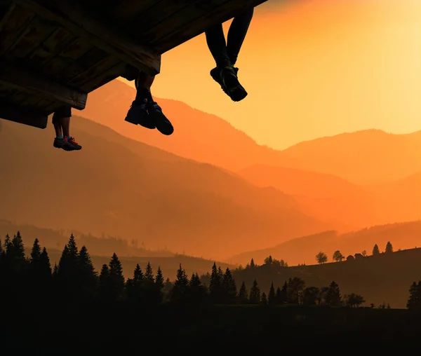 ハイカー ハードなトレッキング一日後木製のバルコニーに座って夕日の美しい光の山をお楽しみください — ストック写真
