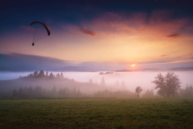 Sabah gökyüzünde paraşütçü siluet kayma
