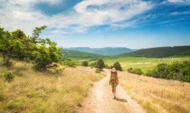 Sırt çantası ile kız yürüyüşçü yol boyunca yürüyüş