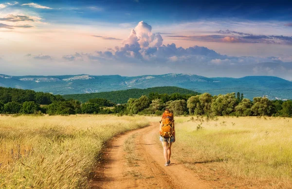 Chica excursionista con mochila caminando por el camino — Foto de Stock