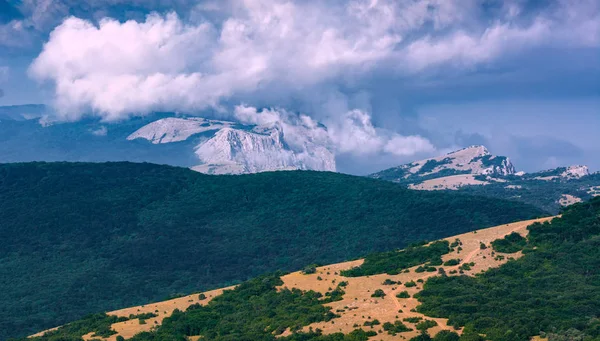 Distant rocky mountains covered with clouds — Stock Photo, Image