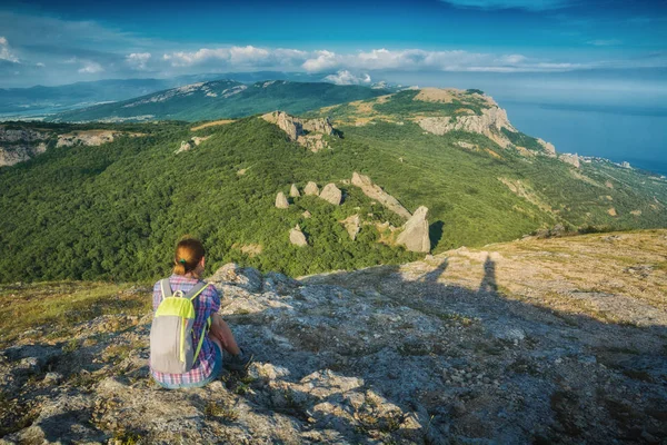 Genç kız bir taşın üzerinde oturuyor. — Stok fotoğraf