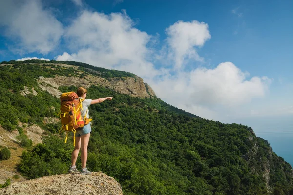 Kız yürüyüşçü vadiye işaret ediyor