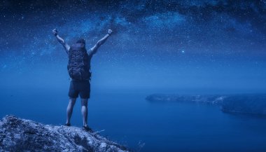 Gece yıldızlı gökyüzüne karşı adam yürüyüşçü