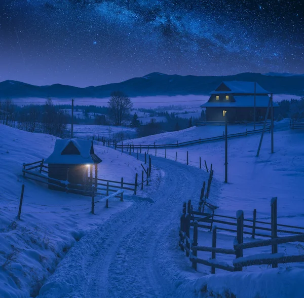 Χιονισμένο δρόμο μέσα από το αλπικό χωριό τη νύχτα — Φωτογραφία Αρχείου