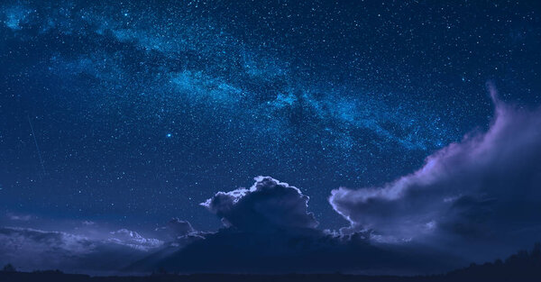 Panorama of night cloudy sky with Milky Way in a starry sky over the fluffy cloud.