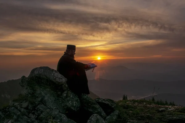 gün batımı ışığında, Romanya okuma rahip silüeti