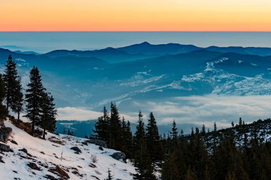 Dağ manzarası ile kış sis Ceahlau, Romaniat, sunse