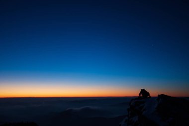 Cliff ve düşünme üzerinde kırmızı günbatımı ve fotoğrafçı meraklısı silhoute kal..