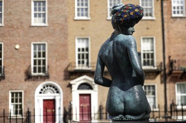 Dublin. İrlanda - 11 Eylül 2018: Merrion Meydanı, arka planda bir Dublin'in ev kadın heykeli