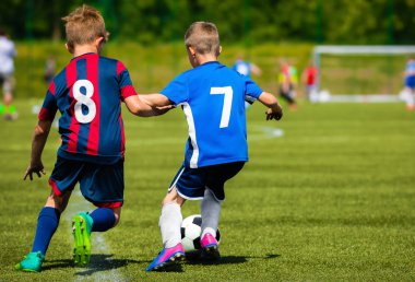 Çim sahada futbol topu tekmeleme iki genç futbolcular. İki okul arasında gençlik spor rekabet spor takımları. Çocuklar futbol turnuvası oyunu.
