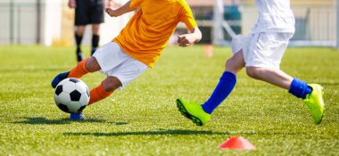 Genç futbol maç rekabet. Çocuklar çim sahada futbol topu tekmeleme. Çalışan ve top için yarışan iki genç futbolcular. Gençlik futbol turnuvası