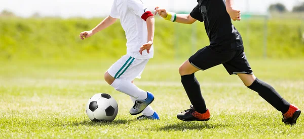 子供のサッカー ボールを蹴るします 若者子供サッカー アクション 緑の芝生の上にボールの後走っている少年たち サッカー選手の白と黒の シャツ — ストック写真