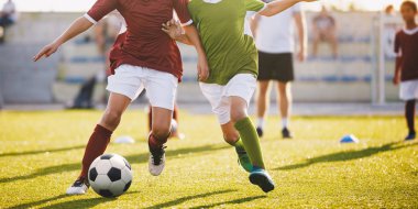 Boys Play Football. Running Football Soccer Players. Kids at Soccer Field Running with Ball. An Action Sport Picture of a Group of Children Playing Soccer Football Game clipart