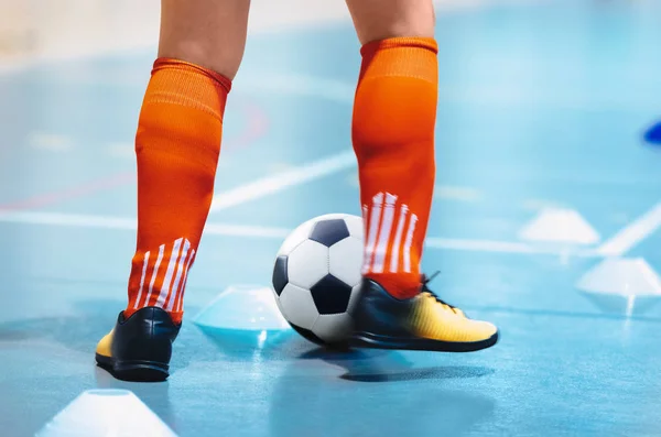 Futsal league. Indoor soccer player in futsal shoes training dribble drill with ball. Indoor soccer training. Running futsal player, soccer ball, white cones. Indoor football player with classic ball.