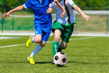 genç erkek futbol futbol oyunu oynarken. Mavi ve beyaz üniformalı çalışan oyuncular