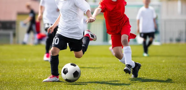実行して フィールドにボールを蹴るサッカー スポーツ ウエアで 人の男の子 背景をぼかした写真の青年フットボールの競争のローアングル画像 — ストック写真