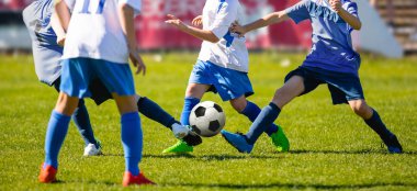 Futbol Spor Giyim 'deki Genç Çocuklar Futbol Çim Sahasında Koşan ve Tekmeleyen Top Grubu. Bulanık Stadyum Arkaplanı ile Düşük Açı Gençlik Futbol Yarışması