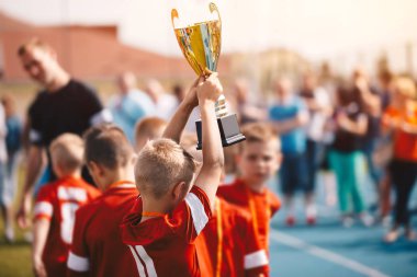 Spor yarışma kazanan çocuklar. Çocuk futbol takımı kupa ile. Fooutball turnuva Futbol Şampiyonası ilkokulda kutlayan çocuklar okul