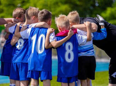 Çocuklar spor takımı. Futbol takım oyuncuları ile birlikte koç ayakta grubudur. Koç verdi genç takım yönergeleri spor. Çocuklar için spor kulübü. Gençlik futbol koçluk