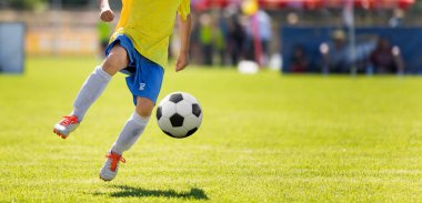 Genç futbol oyuncu topu tekmeleme. Yatay futbol maç görüntü arka plan bulanık Pitch ile