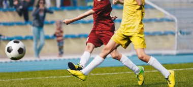 İki Genç Futbolcu Futbol Sahasında Top Alavuruyor. Futbol Yatay Arka Plan. Kırmızı ve Sarı Futbol Formaları Genç Genç Sporcular
