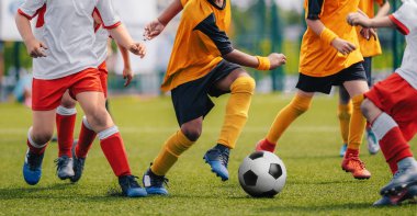 Çocuk futbol oyna. Çalışan ve çim spor sahada futbol topu tekmeleme genç erkek