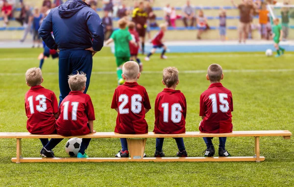 Boys Football Team Sentado no banco de substituição. Kids School Soccer Tournament Match — Fotografia de Stock