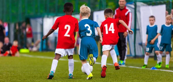 Дети разных национальностей играют в футбол — стоковое фото