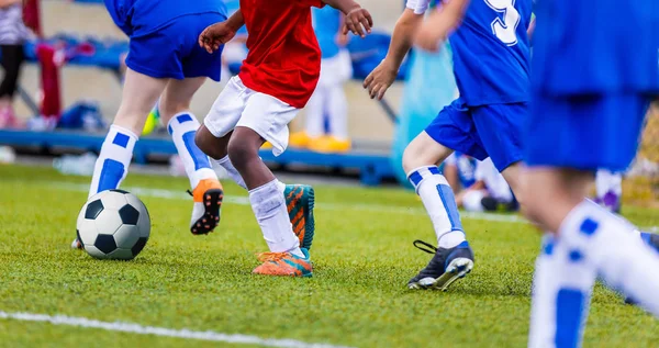 Young Boys in Blue and Red Soccer Jersey Shirts and Soccer Cleats Kicking Soccer Ball (em inglês). Torneio de Futebol para Academias de Clubes de Futebol Juvenil. Competição de Futebol Escolar — Fotografia de Stock