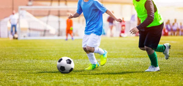 Fiatal fiúk kék és sárga focipólóban és focilabda rúgó focilabdában. Labdarúgó Verseny Ifjúsági Labdarúgó Klubok Akadémiáira. Iskolai Foci Verseny — Stock Fotó