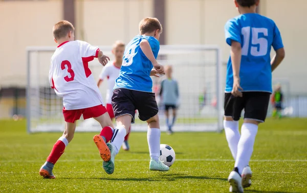Two boys soccer teams competing for the ball during a football match — Stock Photo, Image