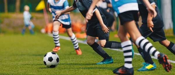 Jóvenes futbolistas corriendo en el campo de fútbol de hierba y patadas pelota. Partido Torneo de Fútbol Infantil —  Fotos de Stock