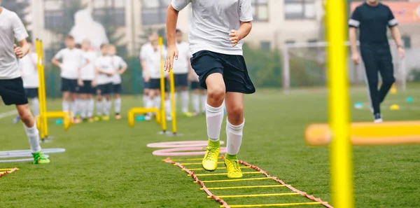 Αγόρι ποδοσφαιριστής στην εκπαίδευση. Νέοι ποδοσφαιριστές στην συνεδρία εξάσκησης. Αγόρια που τρέχουν νέα Κινησία σκάλα. Ασκήσεις σκάλα ποδοσφαίρου — Φωτογραφία Αρχείου