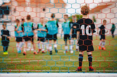 Young Boy Standing in Football Goal. Low Angle Image from Behind the Goal Net. Football Training for Children