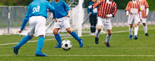 Niños jugando al fútbol. Niños con camisas rojas y azules. Partido de torneo de fútbol para chicos jóvenes — Foto de Stock