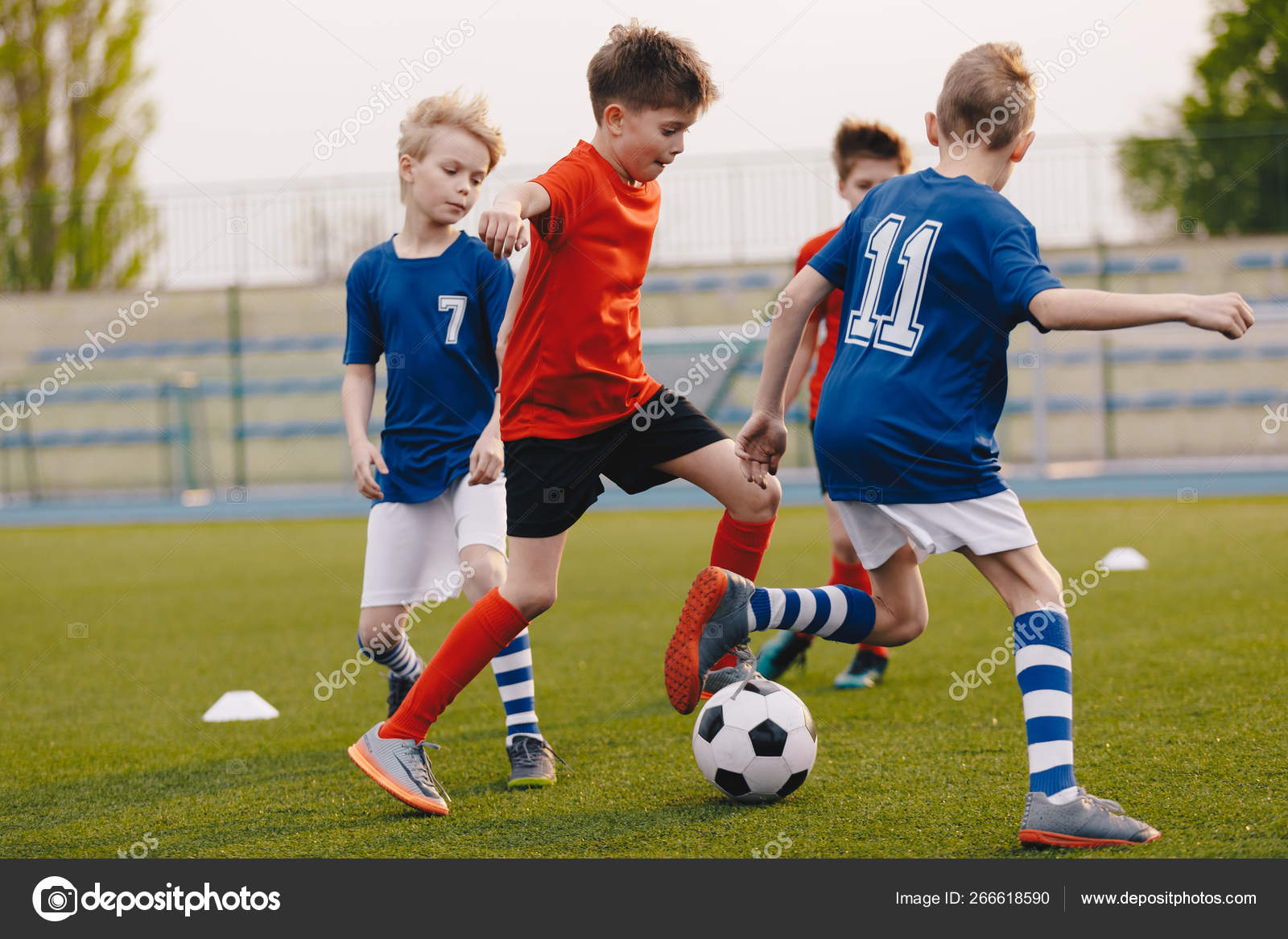 Jogadores de futebol adolescentes chutando bola de futebol campo