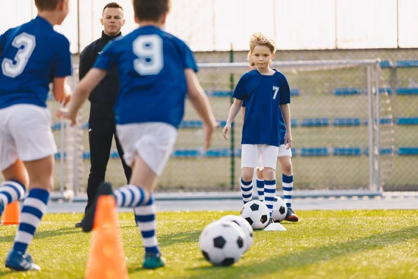 Crianças Treinando Futebol. Jovens rapazes correndo com bola na sessão de treino . — Fotografia de Stock