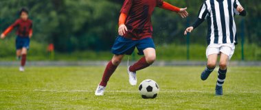 Futbol oyuncuları sahada topu kovalayan