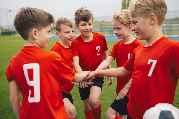 幸せな男の子はチームスポーツをします。学校のスポーツチームで笑顔の子供たち. — ストック写真