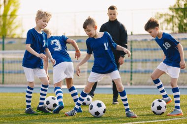 Futbol futbol eğitim matkaplar: Genç oyuncular futbol pratik ile topu çalıştırın. Taze çim sahada futbol eğitim